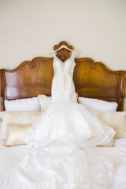 Brides dress hanging from the headboard in the bridal suite at a private venue in murrieta.