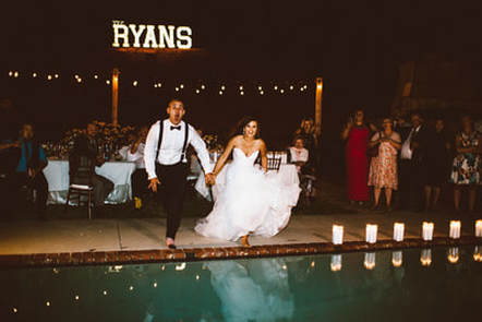 Taking the plunge as the bride and groom jump in a pool.