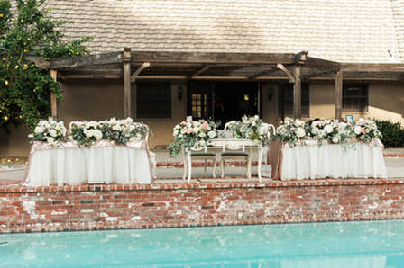 Head table adorned with large floral arrangements.