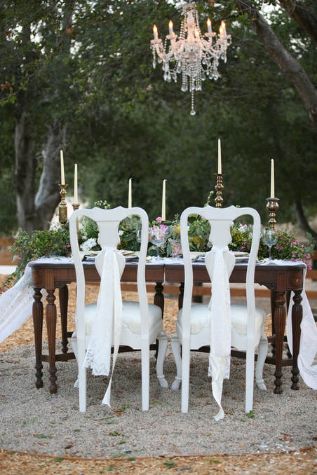 Outdoor wedding table under a chandelier hung from a large oak.