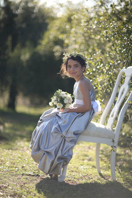 Flower girl sitting all by herself at a private venue.