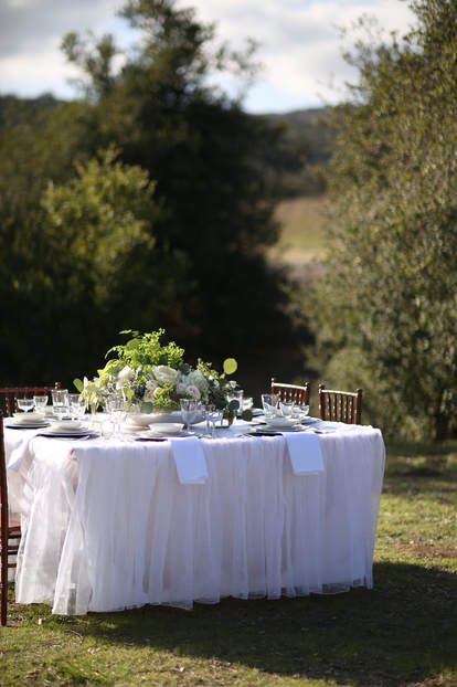 Exclusive wedding venue among the oak trees houses a small guest table.
